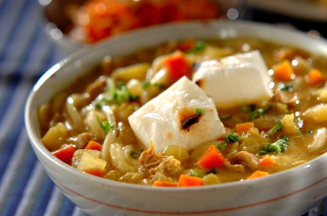 丼鉢に盛りつけられた焼き餅と鶏肉、野菜入りのカレーうどん