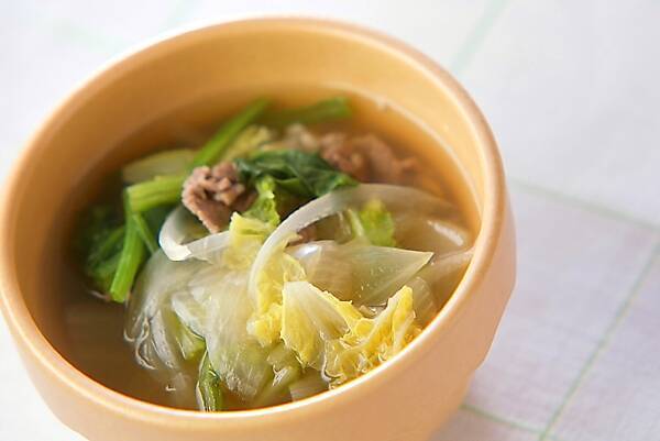 木製の器に盛り付けられている牛肉とほうれん草のしょうがスープ