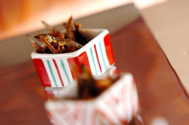 赤と白の四角い器に盛り付けられたクルミ入り田作り