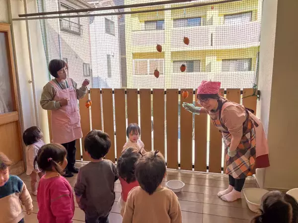 「0・1・2歳から五感で学ぶ日本の食文化　大阪信愛学院幼稚園で毎年恒例の「干し柿作り」を実施」の画像