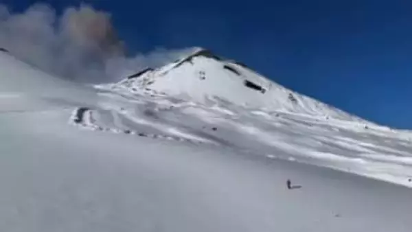 噴火を背にスキーヤーが滑降　イタリア