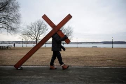 悲嘆に暮れる地域社会へやってくる3メートルの十字架、背負って歩く男性に話を聞く　米国