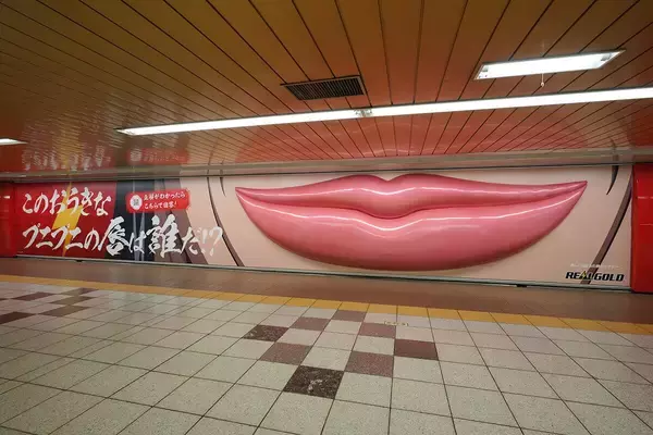 「リアルゴールド」からの挑戦状！幅約7mの大きな唇が新宿駅構内に出現！？