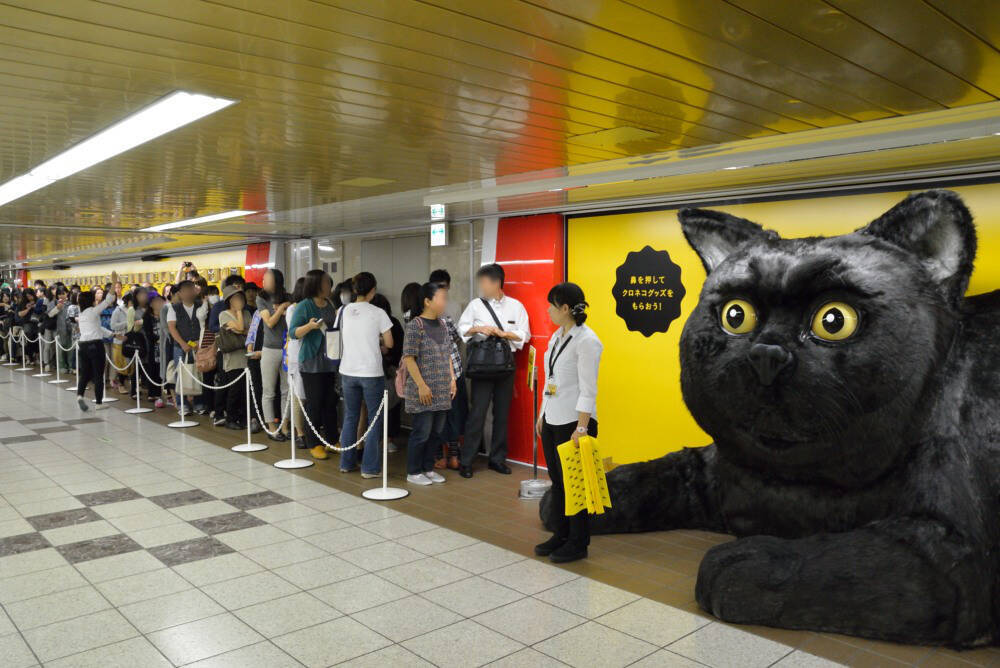 新宿駅にリアルすぎて怖い「巨大クロネコ」出現　真顔で舌をヌルっと出す姿が完全に化け猫