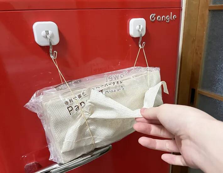 キッチンペーパー、まだ棚に入れてる？　マグネットフックと輪ゴムを合わせる裏ワザに「片手で取り出せる」「つけ替えも簡単」