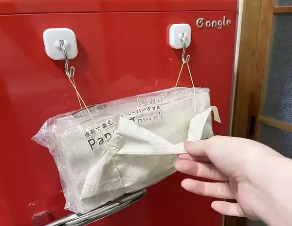 「キッチンペーパー、まだ棚に入れてる？　マグネットフックと輪ゴムを合わせる裏ワザに「片手で取り出せる」「つけ替えも簡単」」の画像