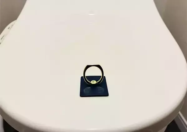 「100均のスマホリングを『便器のフタ』に貼るだけ！　トイレの不快感がなくなる活用法が、こちら」の画像