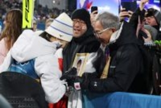 母の遺影に触れる丸山　五輪