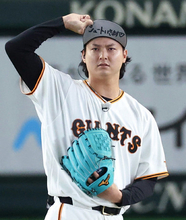 帽子の文字を見せる田中