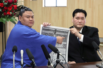 番付表を手にする義ノ富士
