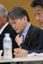 険しい表情の国分専務理事