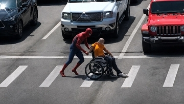 アメリカのスパイダーマン、交差点で立ち往生する車椅子の男性を素早く助ける