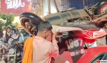 オンリー・インド？交通渋滞から逃れるためにスクーターを肩に担いで歩く男たち