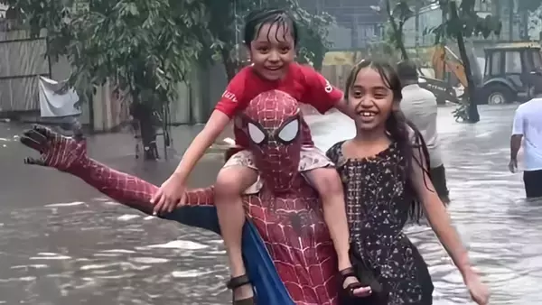 インドのスパイダーマンが豪雨で冠水した道路で困っている人々を助ける