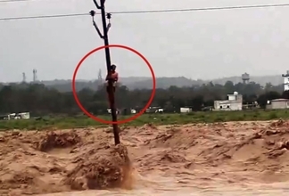 川でトイレがサバイバルタイムに突入！増水で電信柱にしがみつく男性