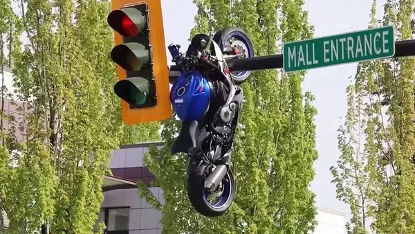 どうしてこうなった？車と衝突したバイクが信号機のポールに吊り下った状態に