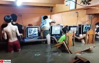 台風で洪水発生、水浸しになりながらネットカフェでゲームをプレイし続けるフィリピンの子供たち