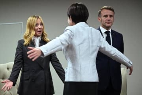 伊首相と抱き合う