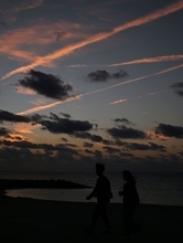 ［沖縄days］飛行機雲がオレンジ色に…　豊見城市・美らSUNビーチ