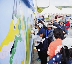伝統継承と地域活性化へ　倉庫の外壁に「桃原ハーリー」　うるま市・宮城島でアート制作イベント