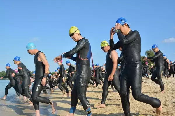 「沖縄・いぜなトライアスロン号砲　海に向け一斉に飛び込む　スイム・バイク・ラン計88キロで健脚競う」の画像
