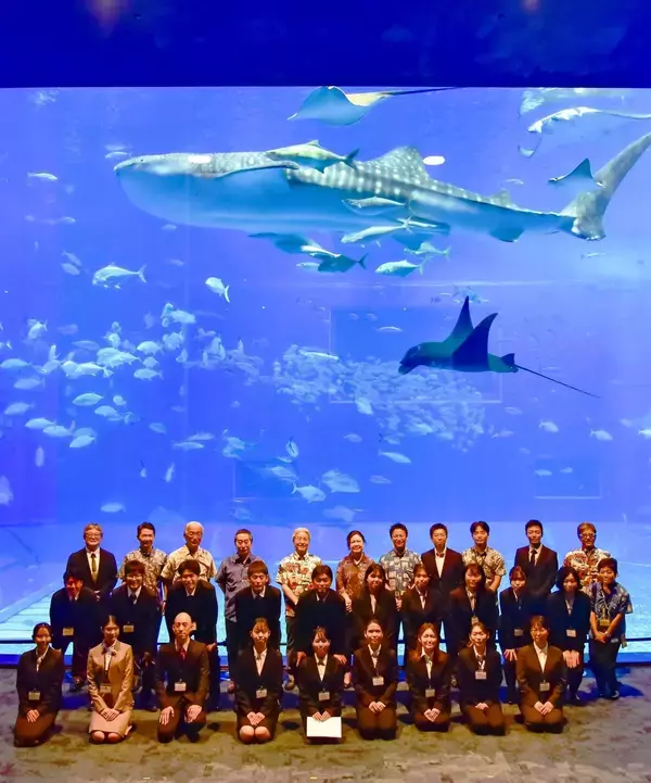 ジンベエザメも大歓迎　沖縄美ら島財団、大水槽を背景に入社式　創立50周年の節目に新入職員20人
