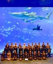 ジンベエザメも大歓迎！　沖縄美ら島財団、大水槽を背景に入社式　創立50周年の節目に新入職員20人