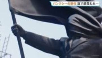 旗で顔覆われたスーツ姿の巨大な像 バンクシー新作がロンドン中心部に現る 「盲目的な愛国心への批判だ」との考察も