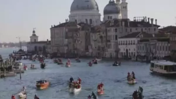 サンタクロースたちがゴンドラに乗ってベネチアの大運河をパレード