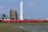 地平をゆっくり染めるまっ赤な電車、空へとのびるまっ白な構造物…ここはどこ？ 構造物の正体は？