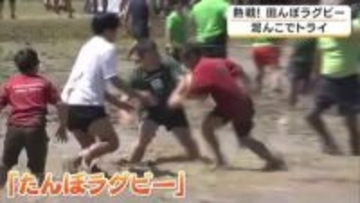 タックル禁止で子どもも大人も泥だらけ　田植え前の田んぼで「たんぼラグビー」　30度に迫る暑さのなか約150人参加　京都・福知山市