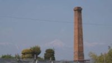 穏やかな青空に…　地域に100年建ち続けた煙突が最後の姿　赤レンガ高さ約20メートル　取り壊し前に住民が別れ惜しむ