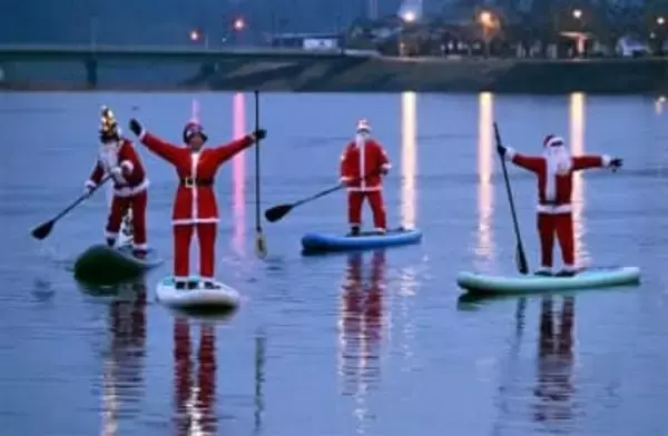 サップに乗りサンタ登場　大分・日田市の三隈川で清掃活動