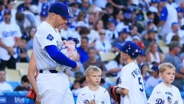 チャーリーくんが10歳の誕生日　妹と愛猫チャンプを抱えてお兄ちゃんの顔　プレゼントの片隅にはパパ・フリーマンのボブルヘッドも