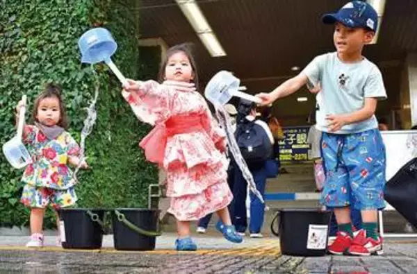 「涼しくなった」ひしゃくで水まき笑顔　子どもらが打ち水体験　入間市駅前で夕涼みを楽しむイベント
