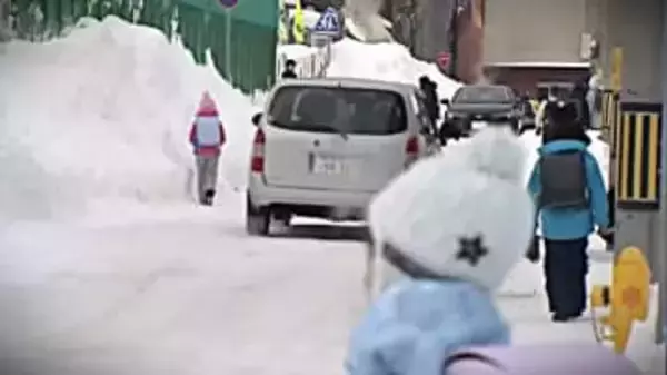 【災害級ドカ雪１週間】道路脇にそびえる巨大雪山の谷間で車道歩く児童たち…路線バスが復旧するもまだまだ影響残るデコボコ路面＜北海道札幌市＞
