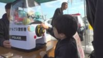 防犯グッズが出るカプセルトイに似顔絵捜査官の似顔絵も　警察が祭り会場で防犯活動　山梨・南アルプス市