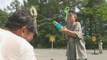 夏の暑さを吹き飛ばす　家族や友人らで水鉄砲打ち合う　清里丘の公園夏祭り　山梨