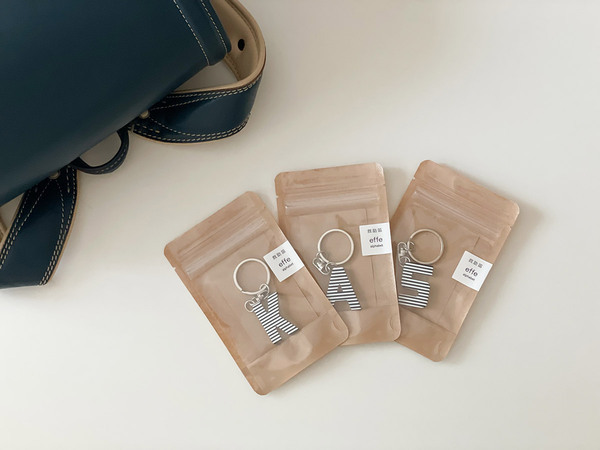 メガネフレームの素材でつくられた、effeのお守りアルファベットキーリング。[PR]