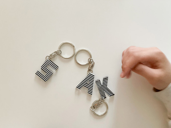 メガネフレームの素材でつくられた、effeのお守りアルファベットキーリング。[PR]