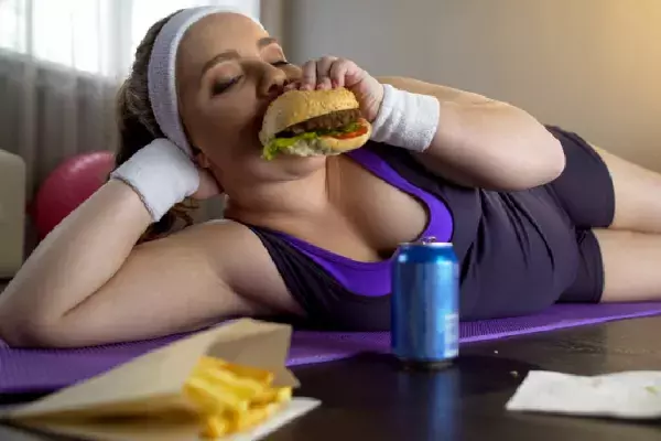 マットの上でハンバーガーを食べる女性