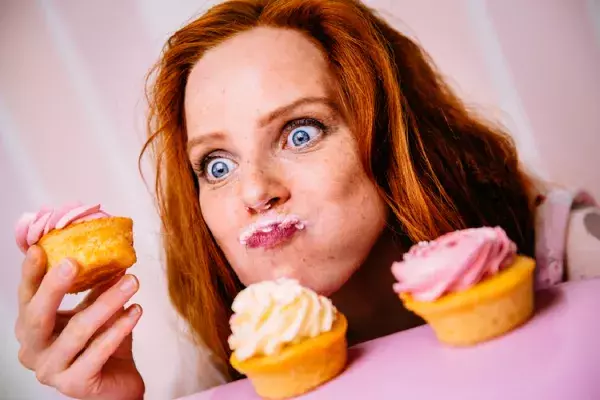カップケーキを頬張る女性