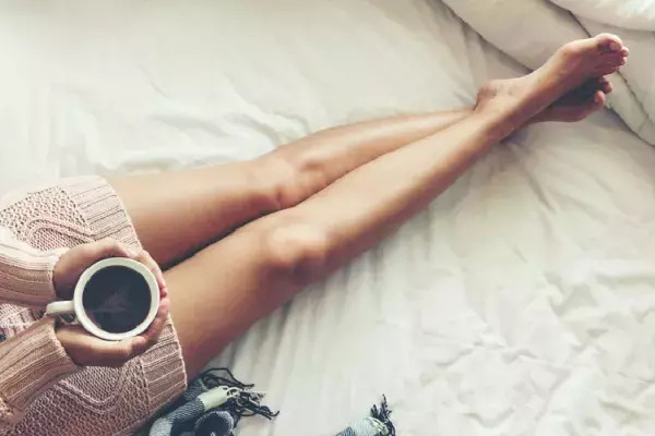 コーヒーを飲む女性の脚
