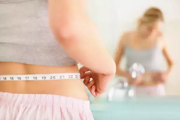 ウエストサイズを測る女性