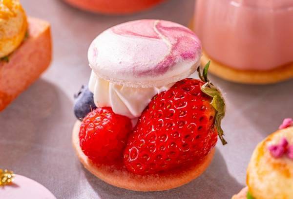 春のうららかな日差しのなか、淡いピンク色の桜と赤く艶やかな色の苺を楽しむコンラッド東京のアフタヌーンティー