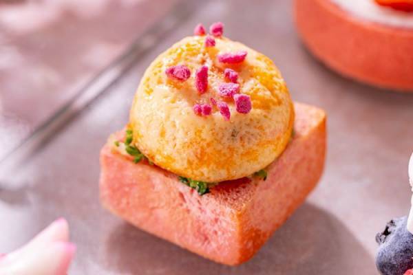 春のうららかな日差しのなか、淡いピンク色の桜と赤く艶やかな色の苺を楽しむコンラッド東京のアフタヌーンティー