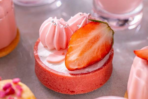 春のうららかな日差しのなか、淡いピンク色の桜と赤く艶やかな色の苺を楽しむコンラッド東京のアフタヌーンティー