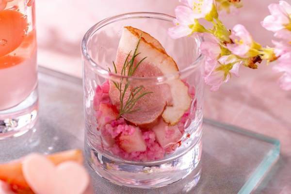春のうららかな日差しのなか、淡いピンク色の桜と赤く艶やかな色の苺を楽しむコンラッド東京のアフタヌーンティー