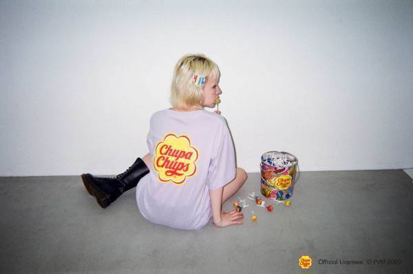 X-girl「チュッパチャプス」のロゴ入りカラフルTシャツ、吹き出し風グラフィック付き