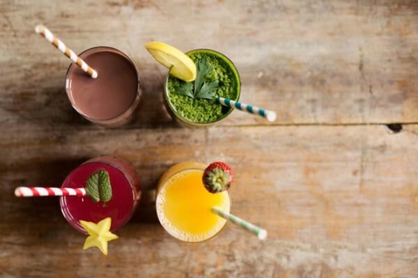 Healthy fresh smoothies with colorful striped straws
